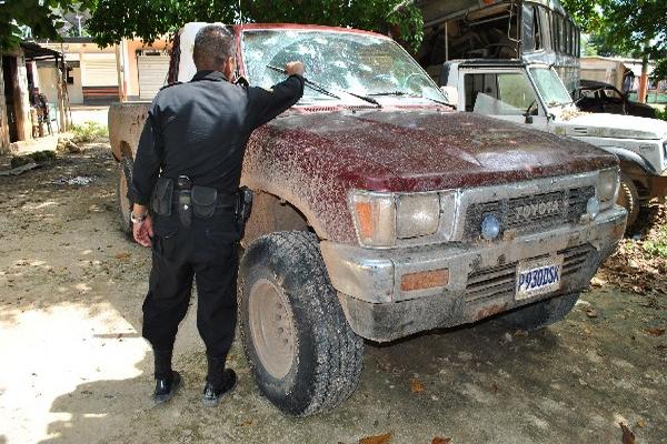 Agente policial muestra  perforaciones de bala en el picop donde se desplazaban las víctimas, en un camino  de tierra que conduce a las aldeas Las Palmas e Ixmucané, La Libertad, Petén.