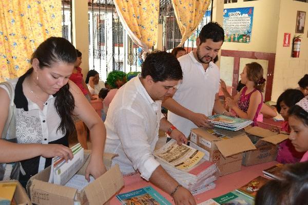 Miembros de asociación Soy Yo y maestros revisan parte de los libros donados.