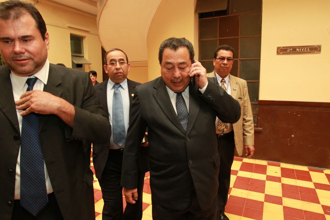 El ministro de Salud, Alfonso Cabrera, conversa por teléfono a su ingreso al Congreso, acompañado de su equipo asesor. (Foto Prensa Libre: Estuardo Paredes)