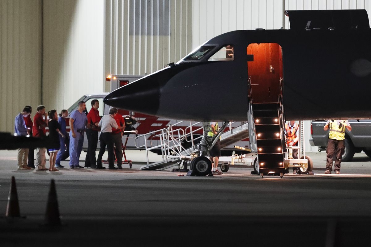 Momento en que estudiantes es bajado del avión militar en Lunken. (Foto Prensa Libre: AP)
