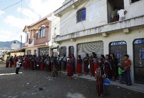 Mujeres de Nebaj hacen fila frente a la sede del Ministerio de Desarrollo Social, para solicitar el pago del bono seguro. El alcalde y candidato opositor critica que el beneficio  se utilice en favor del aspirante del PP.
