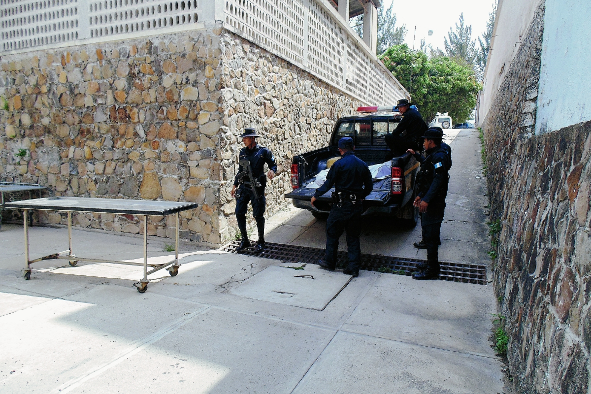 Agentes de  la PNC trasladan a la morgue de Jalapa el cadáver de un joven de 15 años que murió atacado con machete y a balazos. (Foto Prensa Libre: Hugo Oliva)
