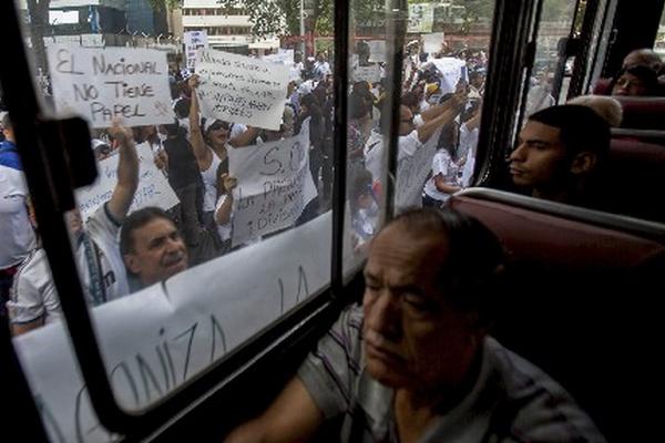 Manifestantes del diario <em>El Nacional</em> piden a Gobierno resolver crisis por falta de papel. (Foto Prensa Libre:AP)<br _mce_bogus="1"/>