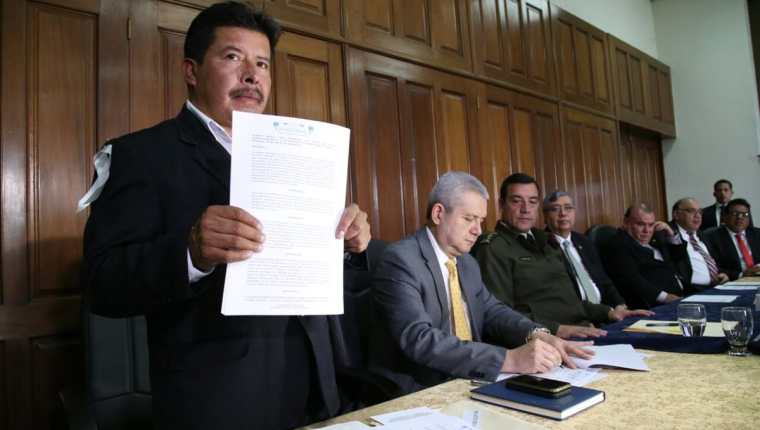 El alcalde de Ixchiguán, David López, levanta el acuerdo firmado junto a otras autoridades. (Foto Prensa Libre: Vicepresidencia)