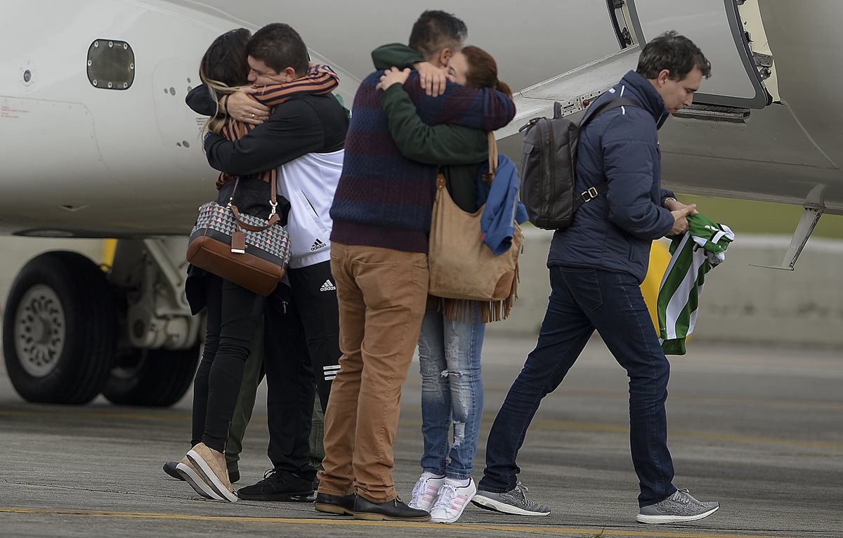 Familiares y amigos de las víctimas y los sobrevivientes de la tragedia aérea se abrazan en Brasil. (Foto Prensa Libre: AFP).