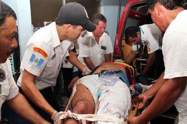Bomberos trasladan a los heridos a un hospital. (Foto Prensa Libre: Rolando Miranda)