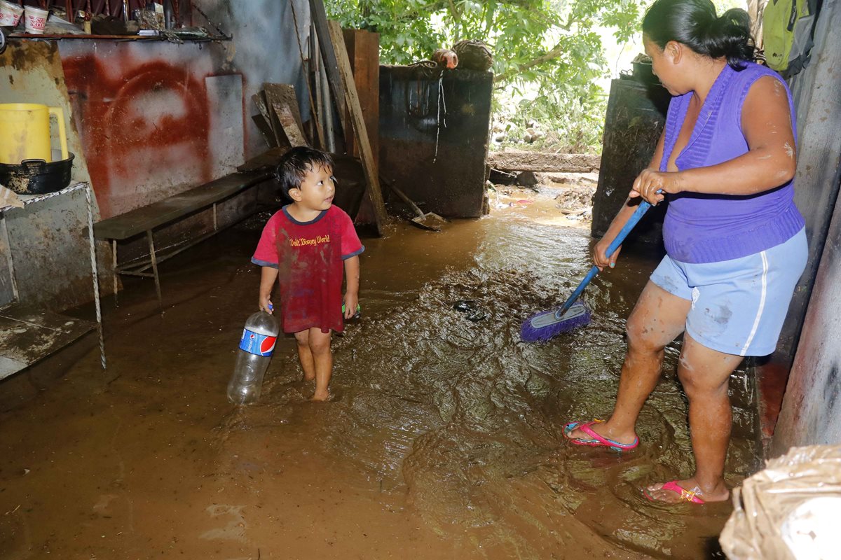 Una mujer saca el agua que se quedó estancada en su vivienda en San Martín Zapotitlán, Retalhuleu.(Foto Prensa Libre: Rolando Miranda)