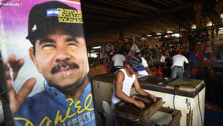 Una pancarta política de Daniel Ortega es vista en un mercado de Managua, Nicaragua. (Foto Prensa Libre: AFP).