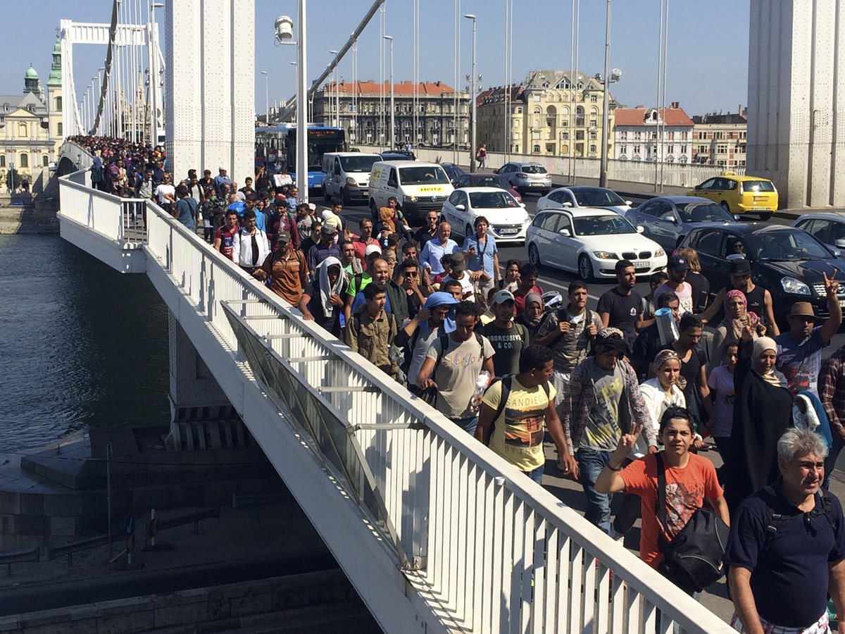 Cientos de inmigrantes cruzan a pie el río Danube en Budapest, Hungría, después que las autoridades cerraran las conexiones ferroviarias. (Foto Prensa Libre: AP).