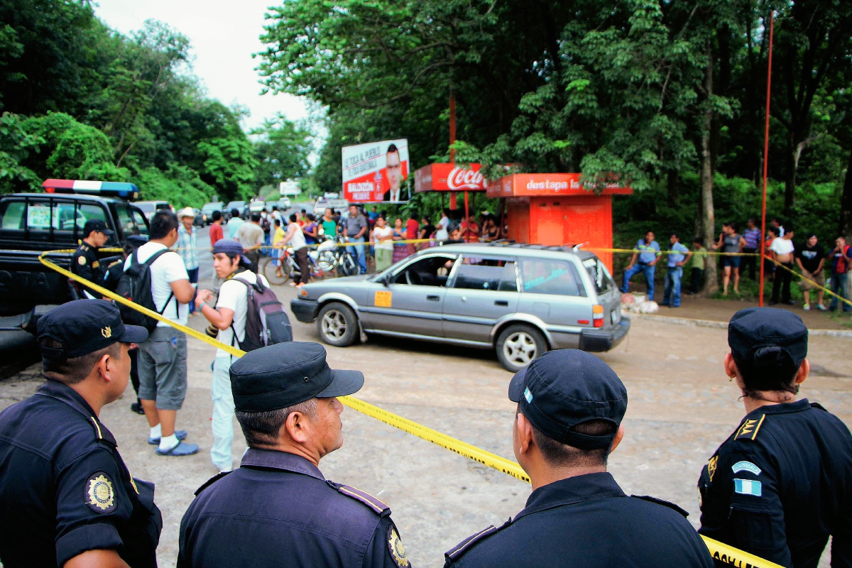 Autoridades resguardan el lugar donde fue atacado a balazos el taxi que conducía Juan Francisco Pantaleón, en Santa Cruz Muluá, Retalhuleu. (Foto Prensa Libre: Rolando Miranda)