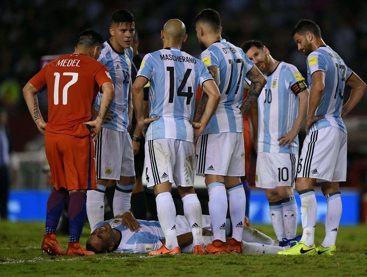 El defensor argentino Gabriel Mercado permanece en el suelo ante la atenta mirada de sus compañeros, en el duelo de ayer entre Argentina y Chile (Foto Prensa Libre: AFP)