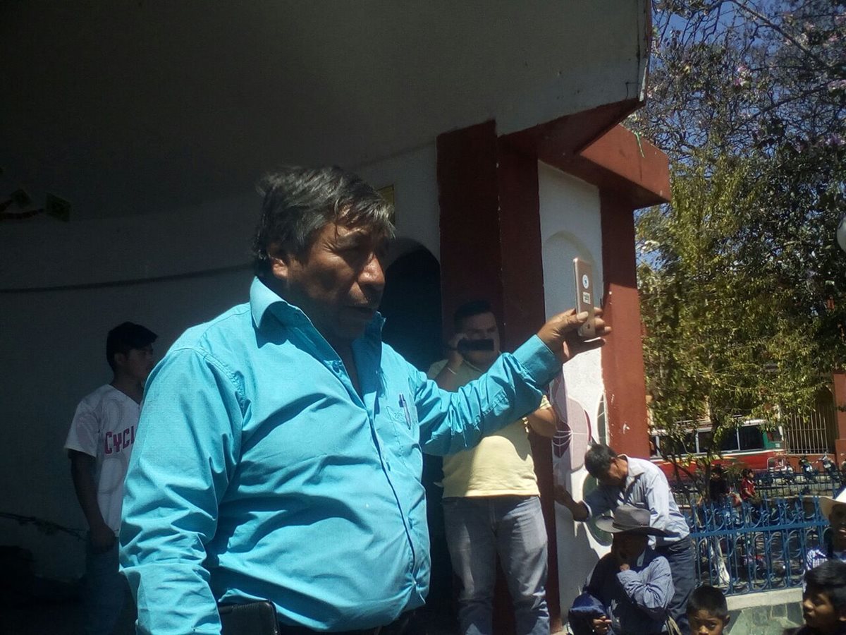Juan Zapeta, alcalde indígena de Santa Cruz del Quiché, enseña a los vecinos el celular que fue robado. (Foto Prensa Libre: Héctor Cordero)