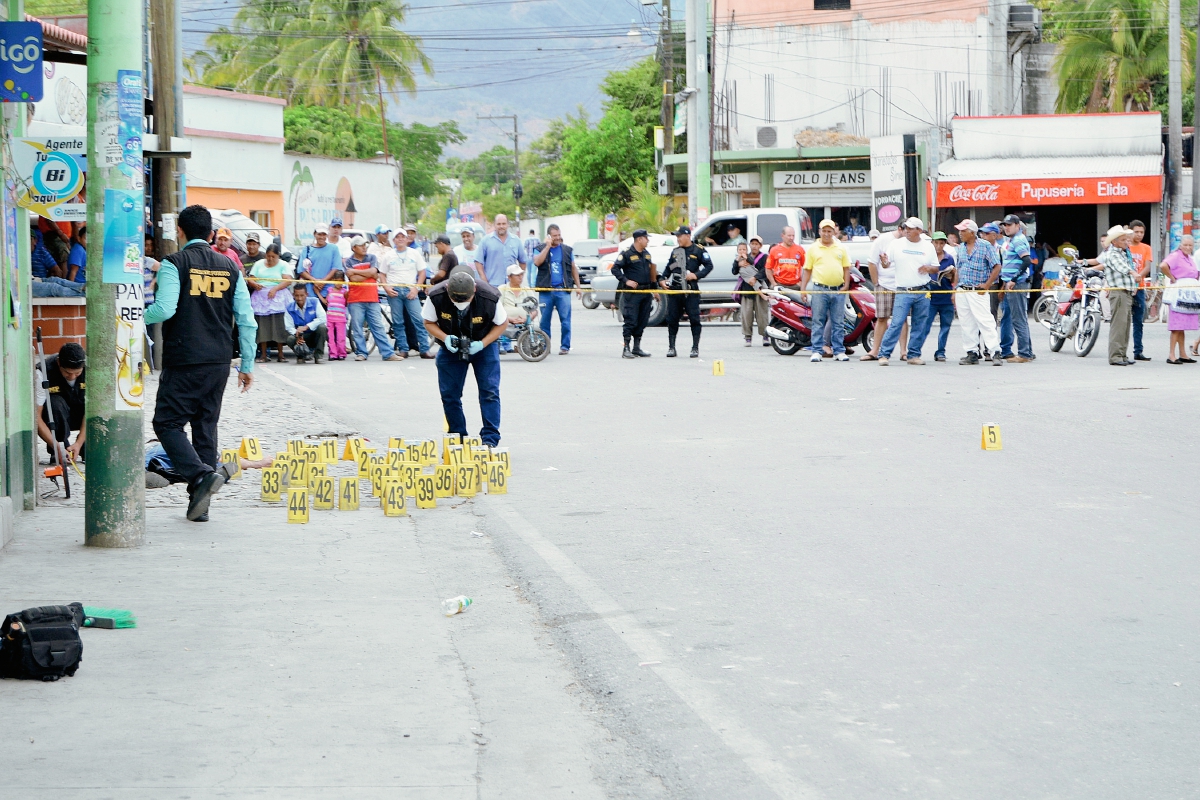 Fiscales del Ministerio Público recolectan evidencias en la escena del crimen donde un inspector de la PNC murió a balazos, en Huité, Zacapa. (Foto Prensa Libre: Víctor Gómez)