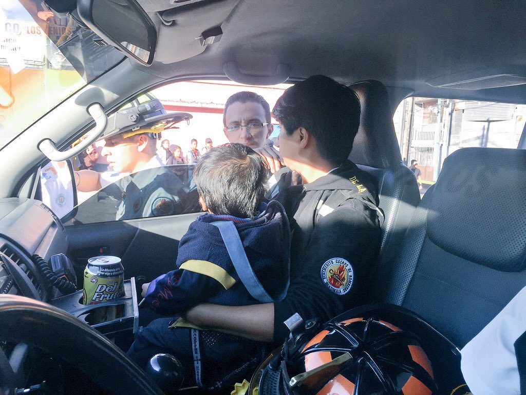 Un Bombero Voluntario cuida al pequeño de dos años que sobrevivió al ataque contra su madre. (Foto Prensa Libre: CBV)