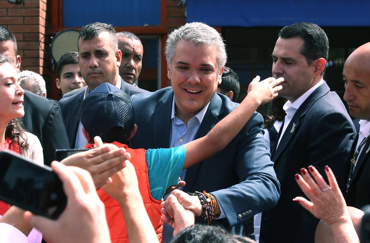 El candidato presidencial Iván Duque (d) saluda a sus simpatizantes a su llega a su puesto de votación, en Bogotá (Colombia). (Foto Prensa Libre: EFE/Mauricio Dueñas Castañeda)