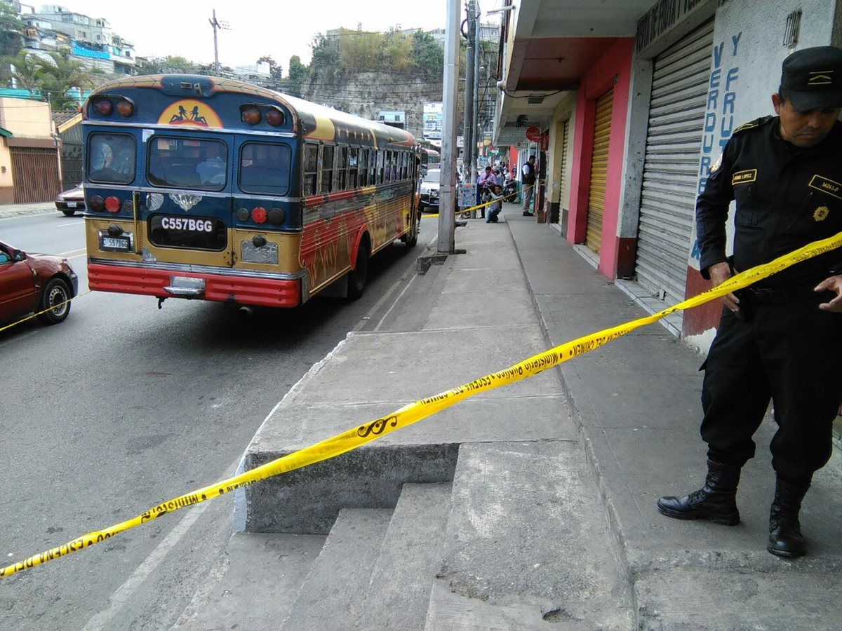 Agentes de la PNC resguardan autobús atacado a balazos en la zona 18 de la capital. (Foto Prensa Libre: Estuardo Paredes)