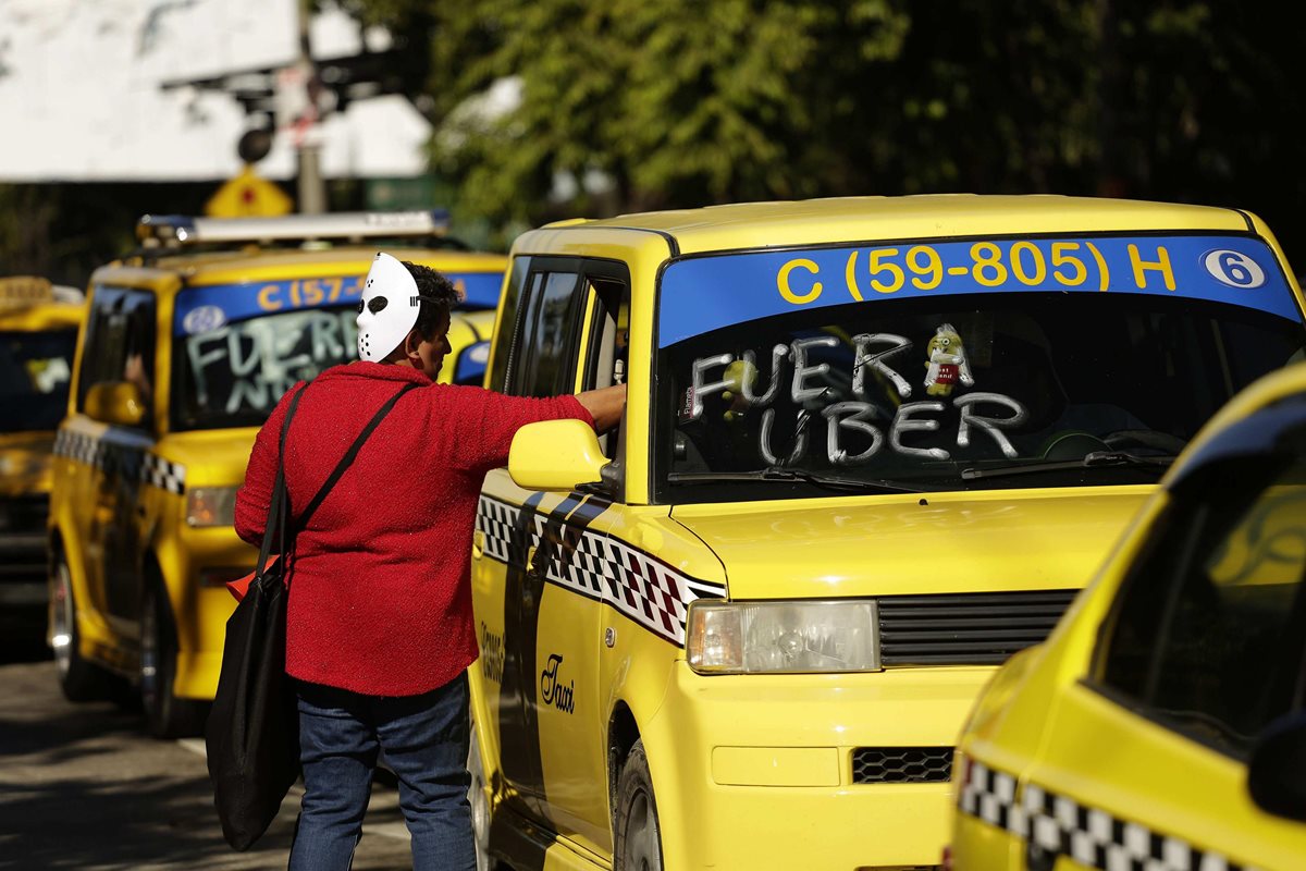 Cientos de taxistas se manifestaron en las principales calles de la capital de El Salvador para exigir que el Congreso deseche una propuesta de reforma para regular las operaciones del sistema privado de transporte Uber y otros similares. (Foto Prensa Libre: EFE)