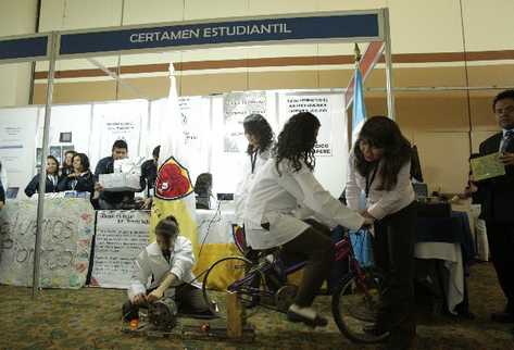grupo de estudiantes  genera energía para un foco mediante una bicicleta.