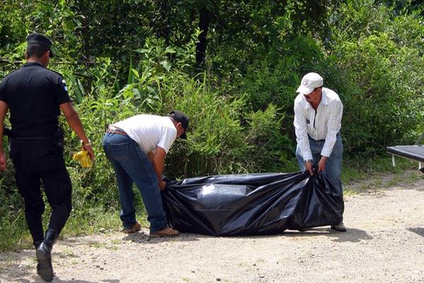 Empleados de una funeraria trasladan a la morgue cadáver de Ramiro Pérez Galicia. (Foto Prensa Libre: Hugo Oliva)