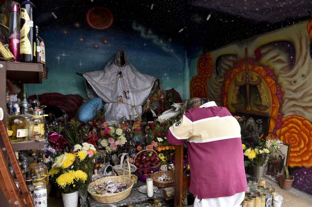 Un hombre reza frente a la imagen de la Santa Muerte.