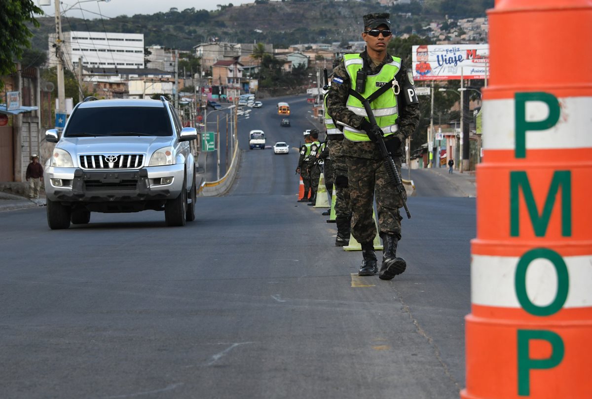 Militares hondureños hacen guardia en Tegucigalpa, durante el estado de emergencia y un toque de queda de 10 días impuesto por el gobierno para detener las manifestaciones. (Foto Prensa Libre: AFP)