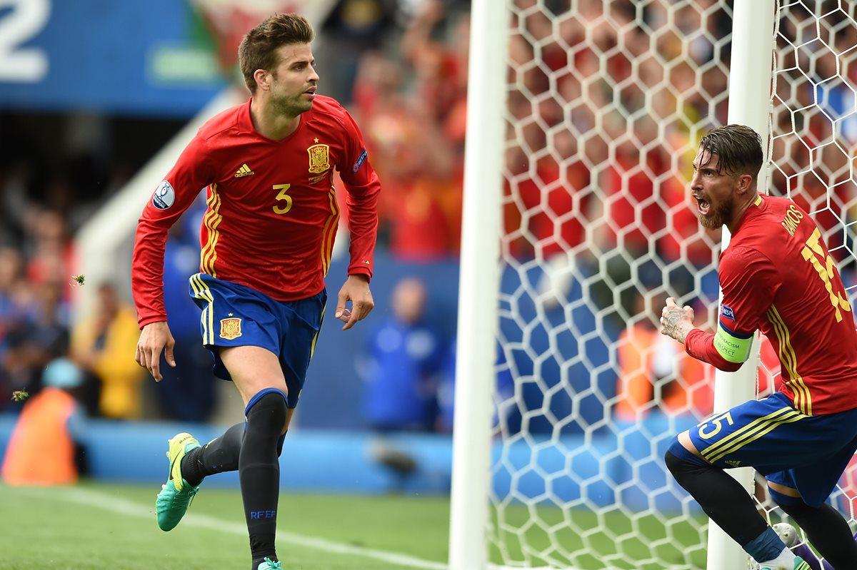 Gerard Piqué corre a celebrar el gol que significó el triunfo sobre España 1-0 frente a su compañero Sergio Ramos. (Foto Prensa Libre: AFP)