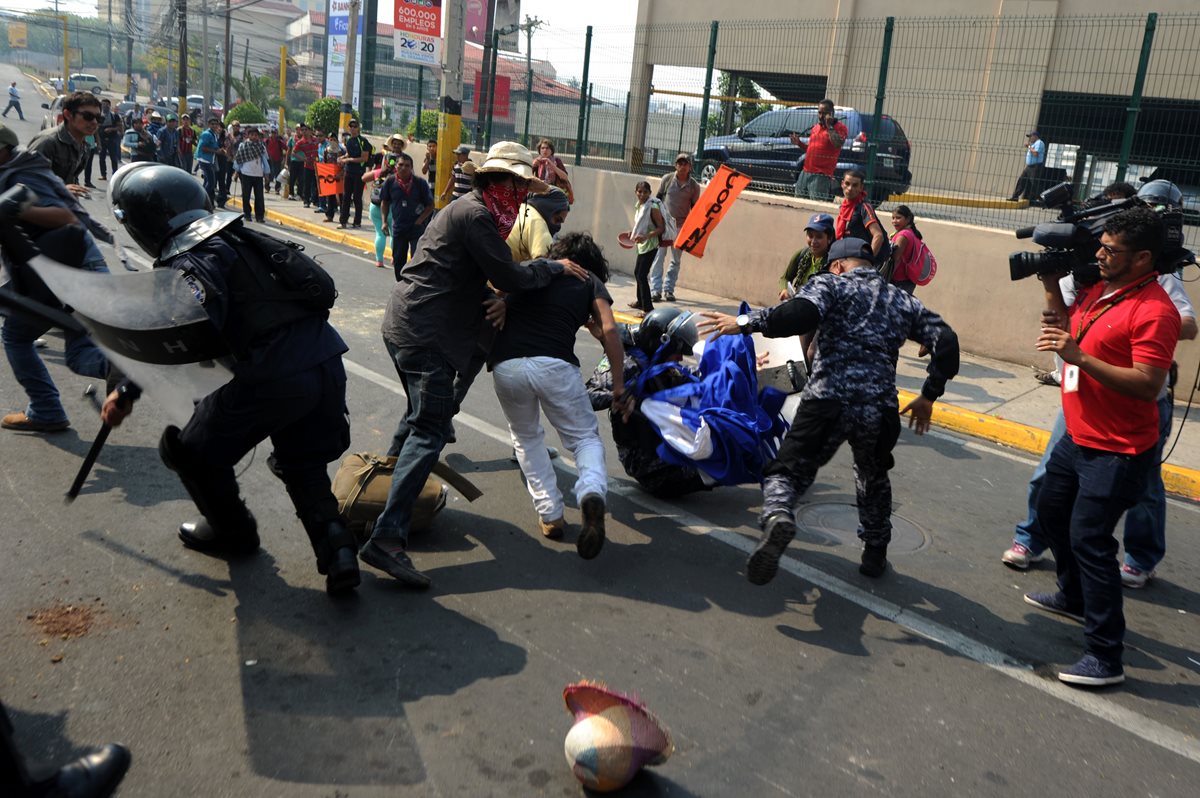 Manifestantes se enfrentan a la Policía en los alrededores de la Casa Presidencial de Honduras donde exigían justicia por la muerte de la activista Berta Cáceres. (Foto Prensa Libre: AFP).