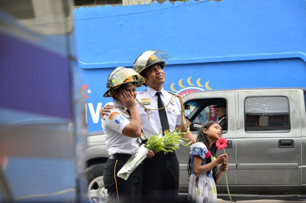 Marina y su hija Samantha, observan el cartel con el cual Carlos le pidió matrimonio, que desplegaron en la Estación de Bomberos Voluntarios en Quetzaltenango. (Foto, Prensa Libre: Stereo 100)