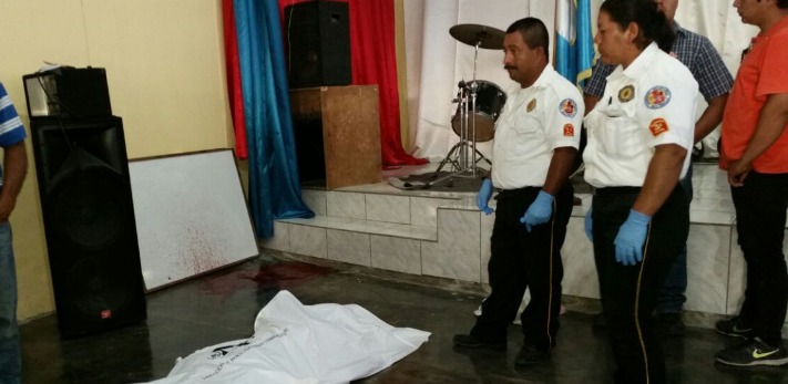 El cadáver de un hombre atacado con arma cortante es resguardado por socorristas en Poptún, Petén. (Foto Prensa Libre: Rigoberto Escobar)