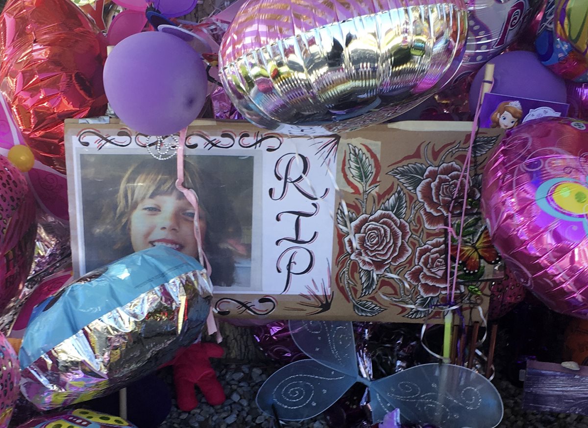 La fotografía de la niña de 10 años se observa en medio de globos colocados un día después del asesinato en Nuevo México. (Foto Prensa Libre: AFP).