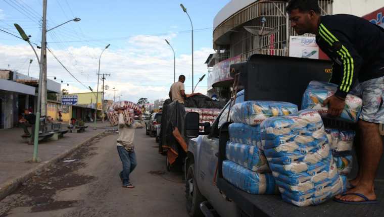 Un grupo de venezolanos se abastece de alimentos en la ciudad brasileña de Pacaraima fronteriza con Venezuela. (Foto Prensa Libre: EFE).