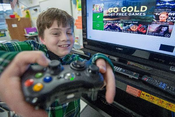 Sawyer Whitely, niño autista, se divierte  con una consola X-box. (Foto Prensa Libre: AFP)
