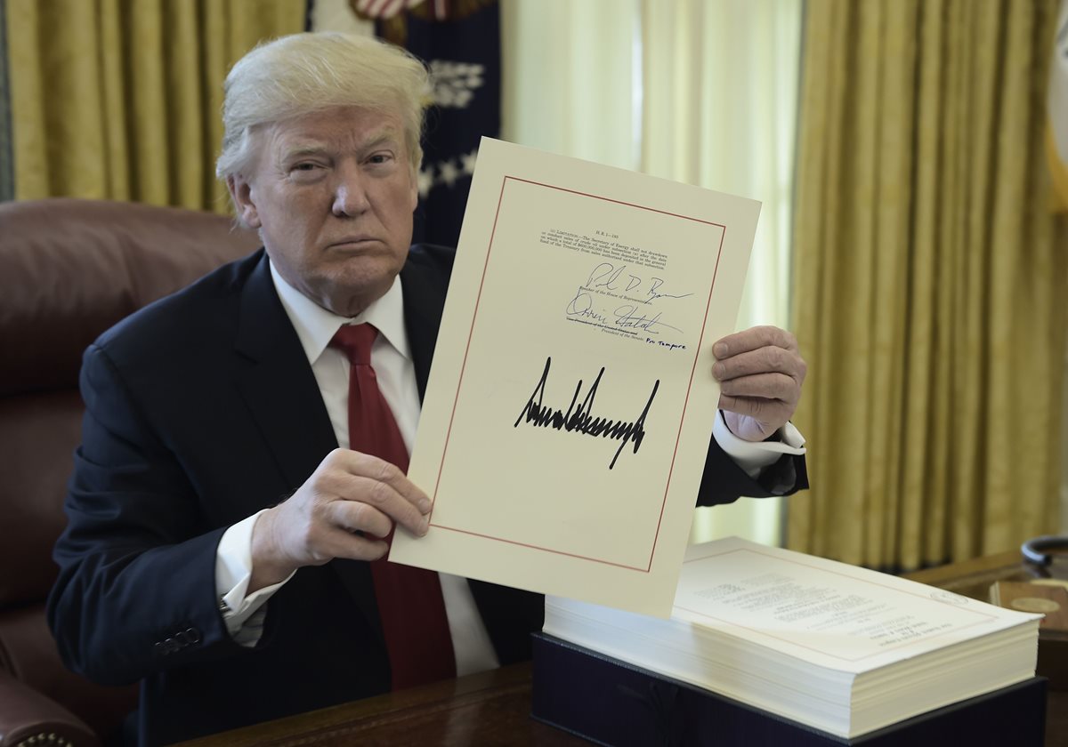 Donald Trump firmó la reforma fiscal antes de irse de vacaciones a Florida. (Foto Prensa Libre: AFP)