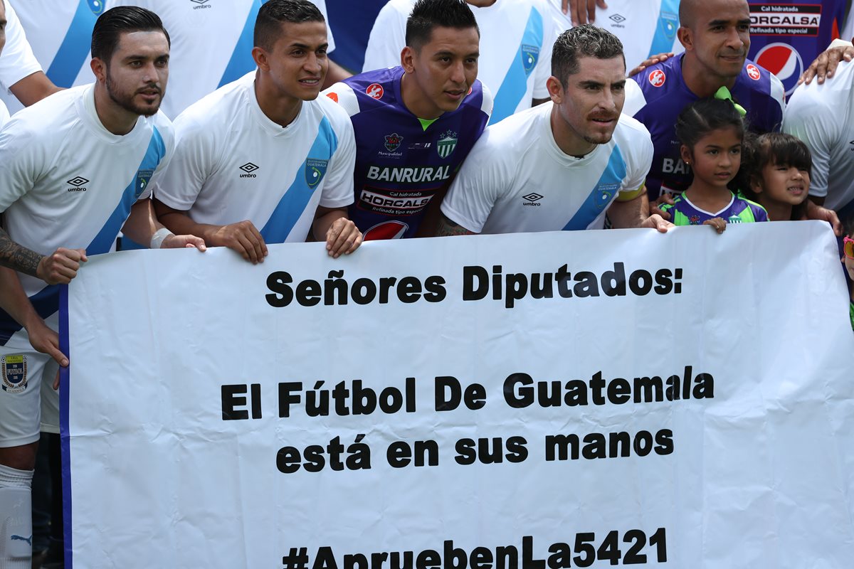 Jugadores cremas muestran una manta con un mensaje dirigido a los diputados del Congreso de la República antes del juego contra Antigua GFC. (Foto de Francisco Sánchez).