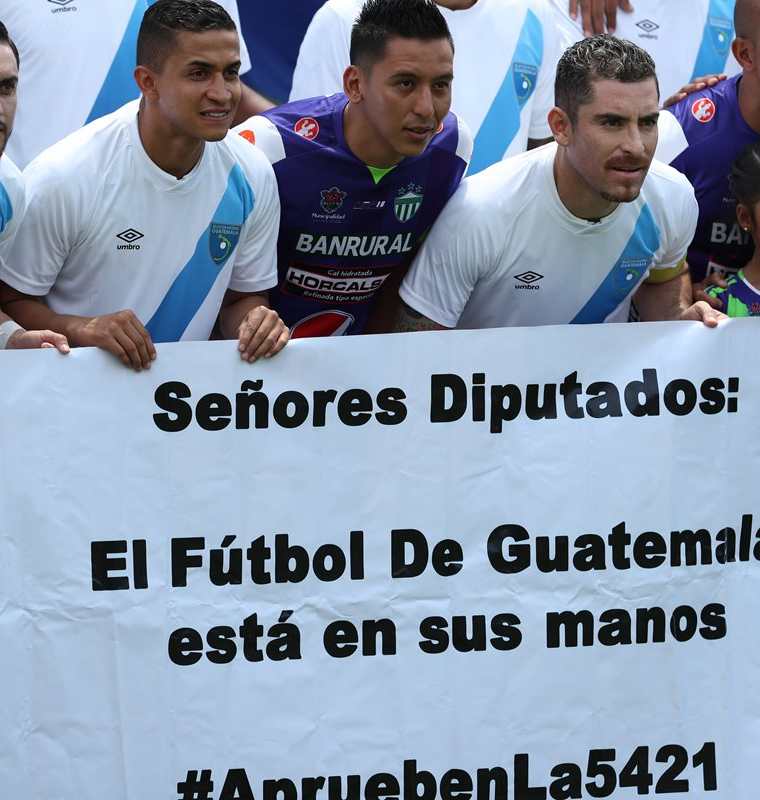 Jugadores cremas muestran una manta con un mensaje dirigido a los diputados del Congreso de la República antes del juego contra Antigua GFC. (Foto de Francisco Sánchez).