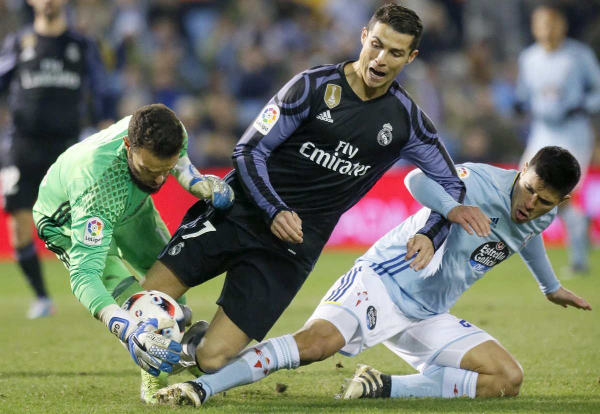 Cristiano Ronaldo no puede superar a dos jugadores del Celta de Vigo. (Foto Prensa Libre: AFP)