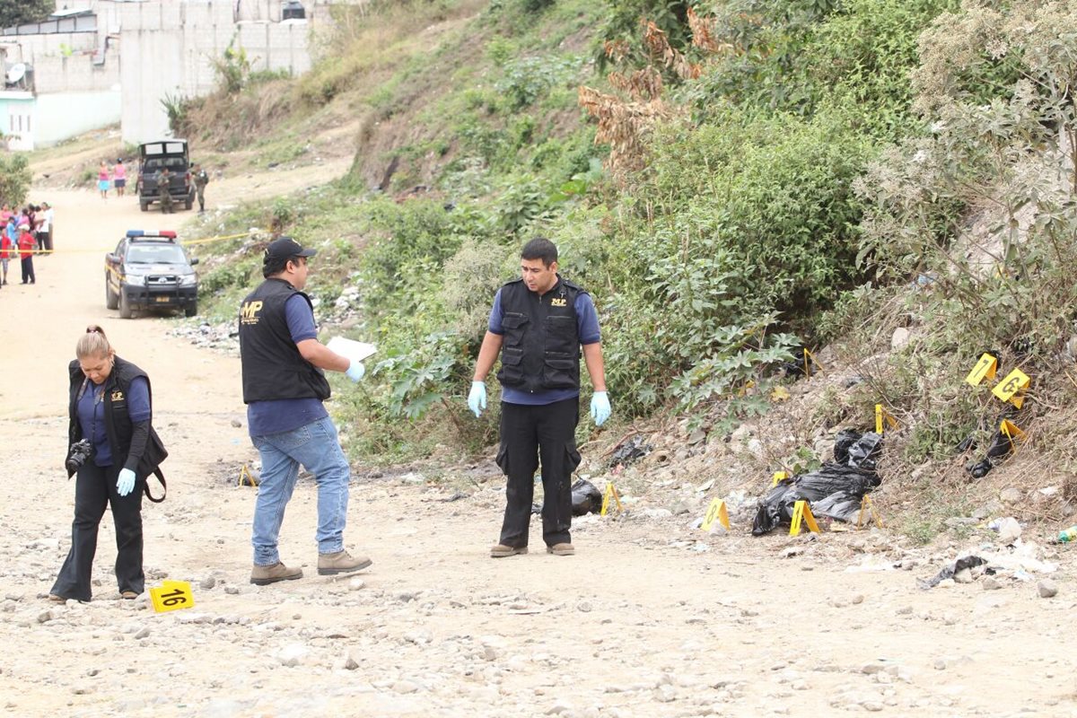 Agentes del MP documentan y embalan los 17 paquetes con restos humanos, en San Pedro Ayampuc. (Foto Prensa Libre: Érick Avila)