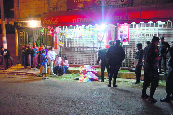 Familiares y  vecinos observan el cuerpo de Elmer Antonio López, de 32 años, quien fue asesinado frente a una tienda en Boca  del Monte. (Foto Prensa Libre: CVB)