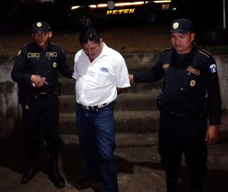 Dos agentes de la Policía Nacional Civil custodian hacia el juzgado a Joel Coy Caal por disparar al aire en el casco urbano de Sayaxché. (Foto Prensa Libre: Rigoberto Escobar)