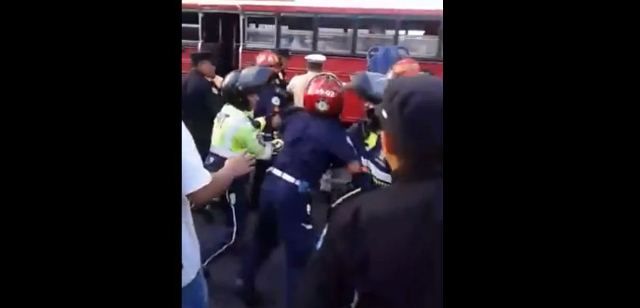 Bomberos Municipales, Voluntarios, agentes de tránsito de Mixco y Guatemala, entre golpes y empujones se disputan el auxilio a un herido de bala. (Foto Prensa Libre: KimboKrazyMusic)
