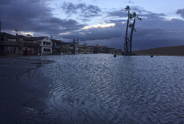 El agua de un río aumenta a lo largo de la playa en Seal Beach, California. (AP).