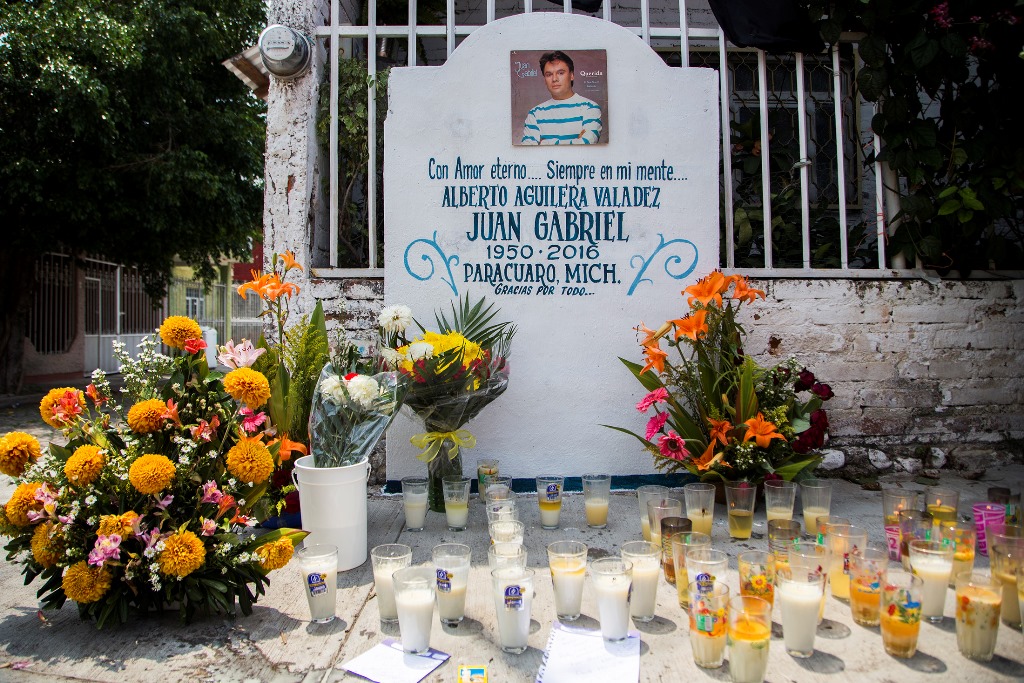 Las velas y las flores se ven en un altar en Parácuaro, Michoacán, México, lugar donde nació Juan Gabriel. (Foto Prensa Libre: AFP)