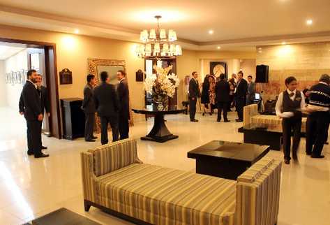 Invitados conversan en el salón principal de Capillas Señoriales de Xela, durante inauguración.