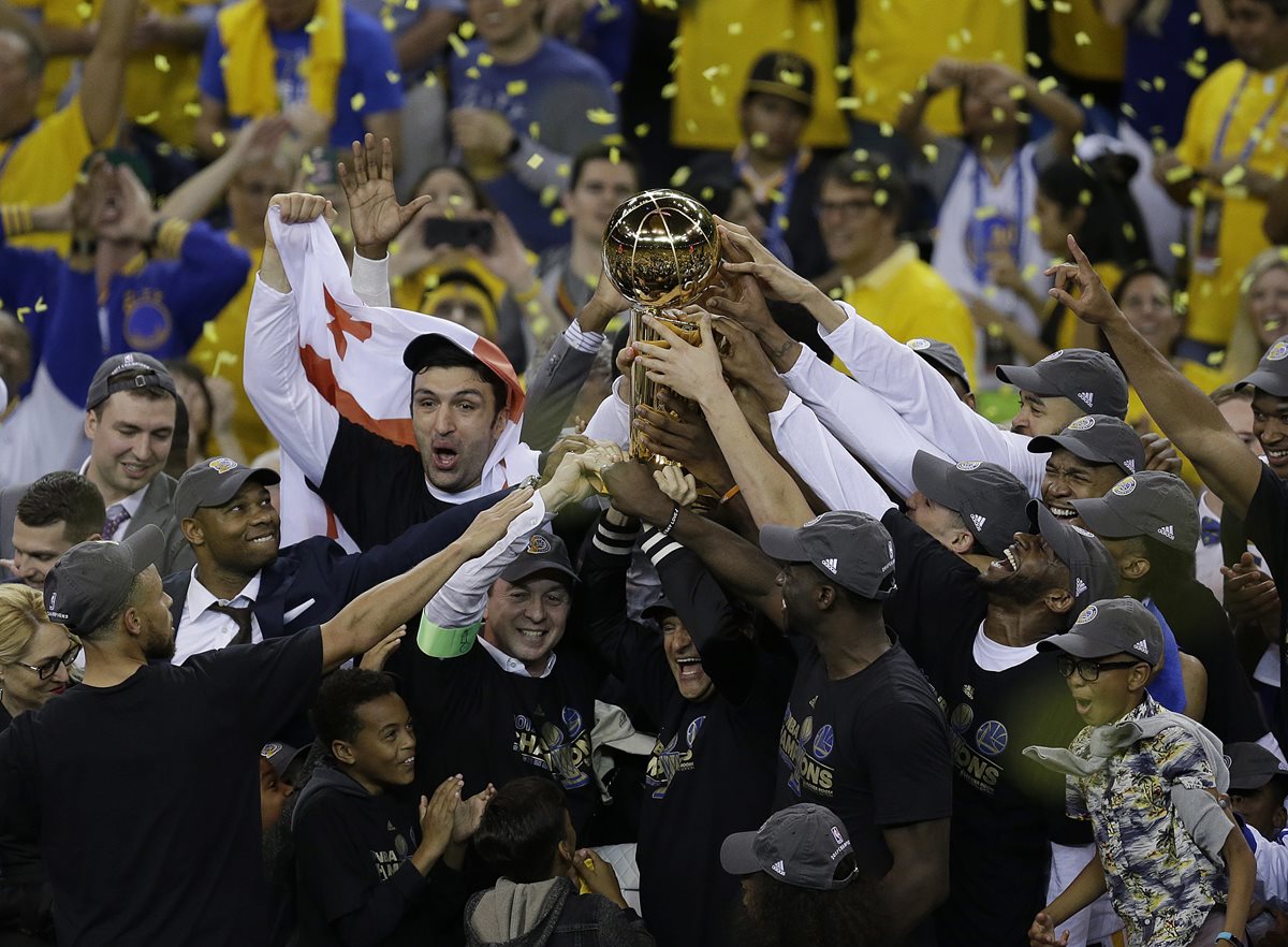 Los jugadores de los Warriors de Golden State, celebran con el trofeo de campeones de la NBA. (Foto Prensa Libre: AFP)