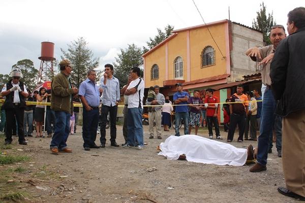 Familiares y curiosos permanecen junto al cuerpo de Marvin Leonardo García Gómez, cuñado del alcalde de Huehuetenango. (Foto Prensa Libre: Mike Castillo)