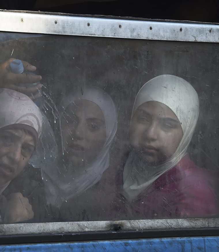 Tres mujeres llegadas de Afganistán, miran por la ventana de un tren con destino a Serbia en la estación de Gevgelija, Macedonia. (Foto Prensa Libre: EFE).