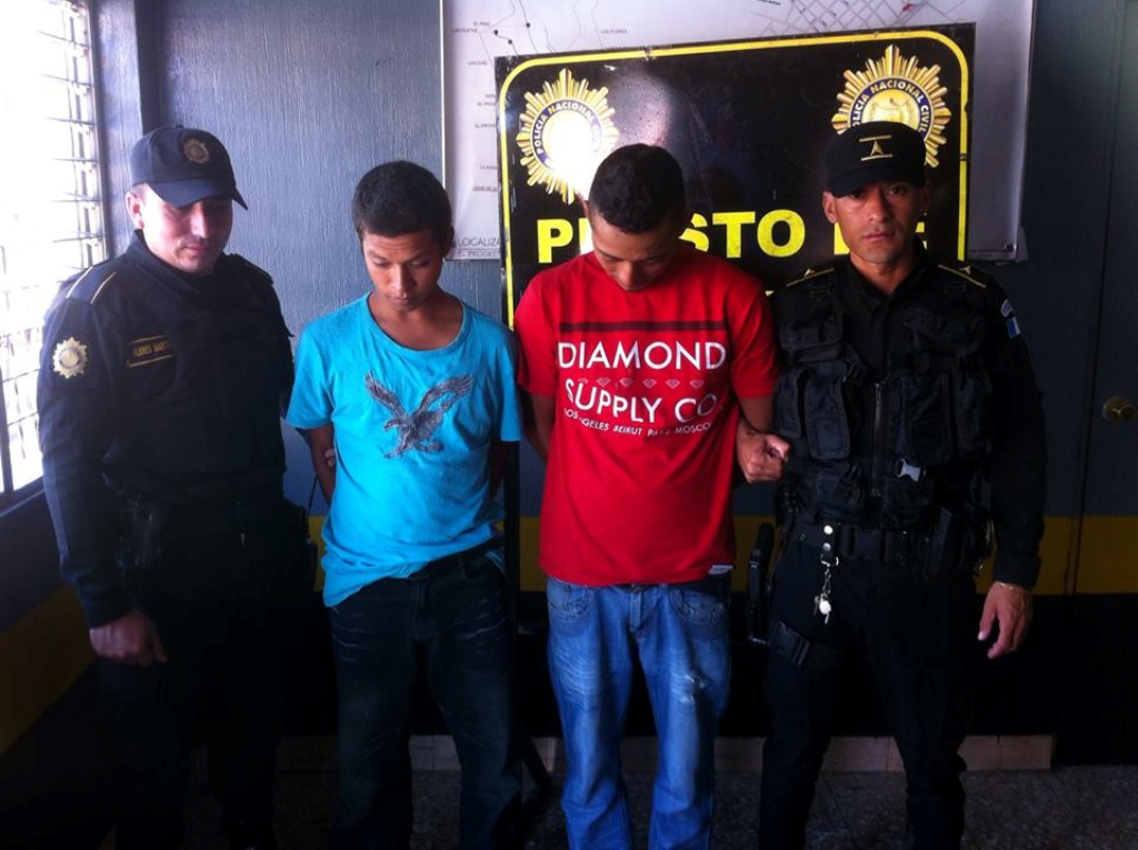 Agentes de la Policía Nacional Civil custodian a los dos capturados, señalados de asaltantes, en Jutiapa. (Foto Prensa Libre: Óscar González)