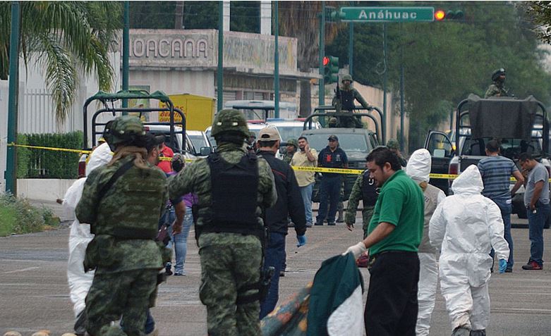 Forensese evalúan uno de los cuerpos que fueron encontrados en Nuevo Laredo con señales de tortura. (Foto Prensa Libre: AFP).