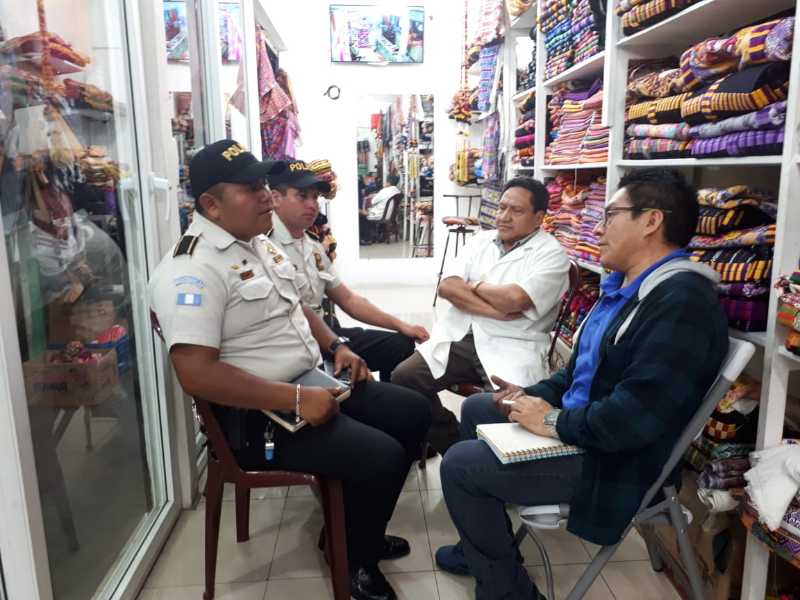 Agentes de la Policía Nacional Civil se reunieron con los comerciantes en un puesto del mercado La Democracia.(Foto Prensa Libre: Fred Rivera)