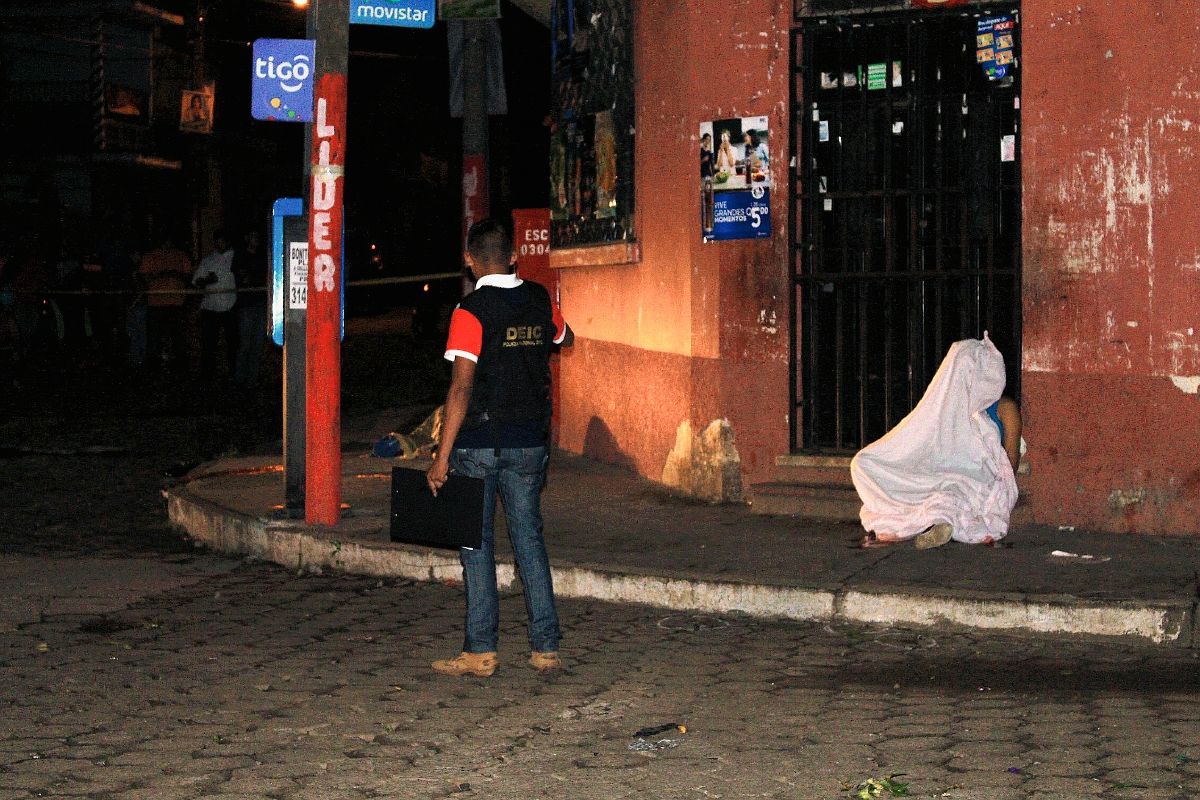 Los cuerpos de dos supuestos extorsionistas cayeron a la banqueta luego de haber sido atacados a balazos en la zona 3 de Escuintla. (Foto Prensa Libre: Carlos Enrique Paredes)